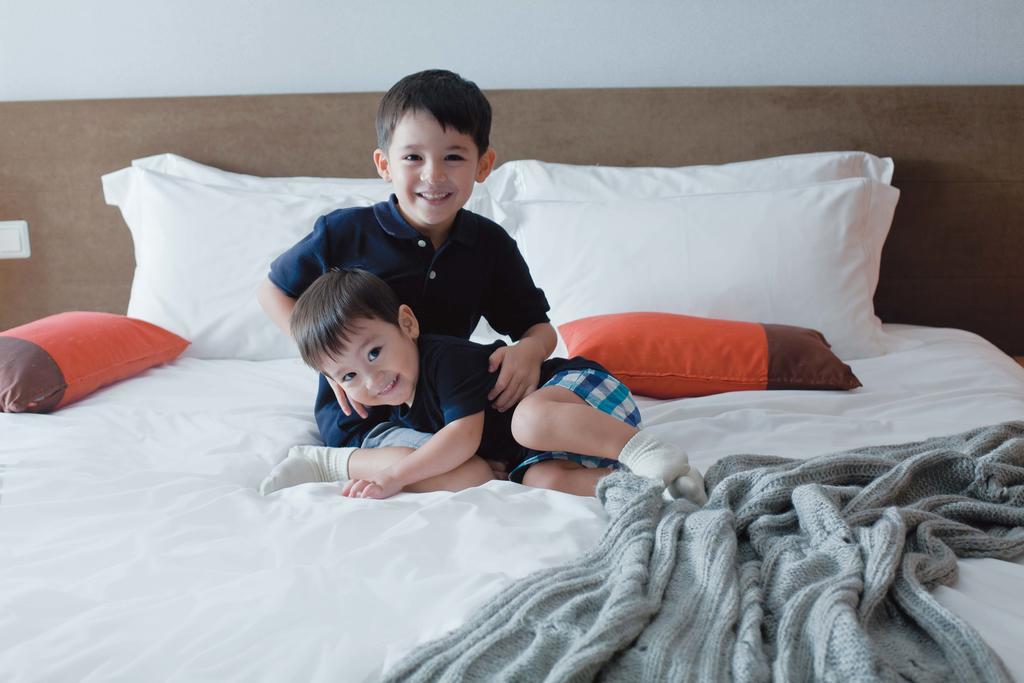 Fraser Place Robertson Walk Singapore Buitenkant foto Two children playing on a bed